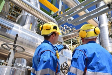 2-workers-in-oil-refinery-yellow-hard-hats-USED-A-LOT-iStock-1039704750-1-2048x1367